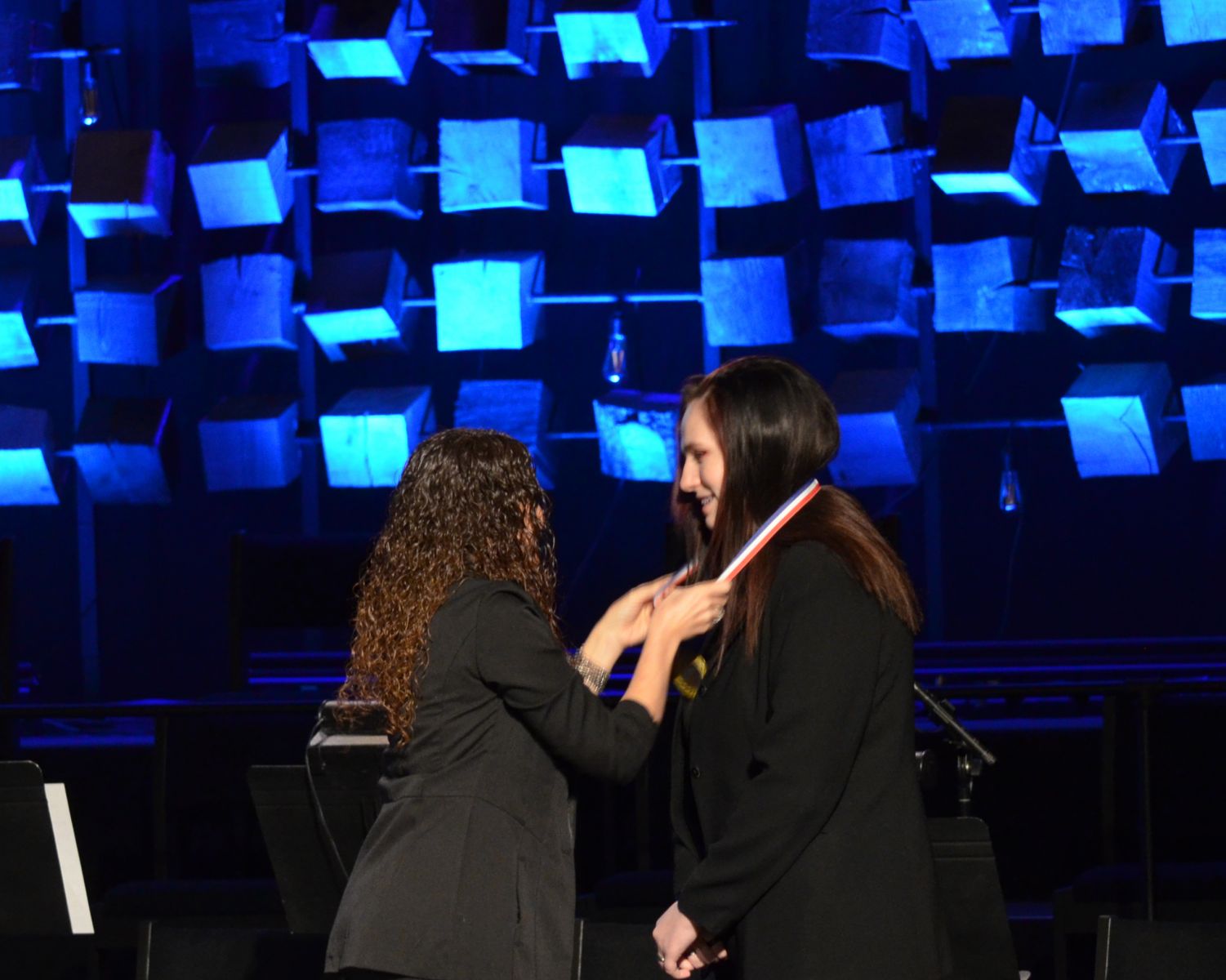 Brooklyn Bucher receives a medal from Business Instructor Kelly Miller at the BPA Region 8 Awards.